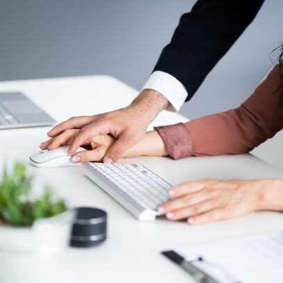A man holding a woman’s hand while using a mouse