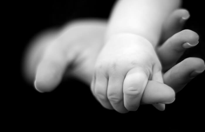 A child holding the hand of an adult